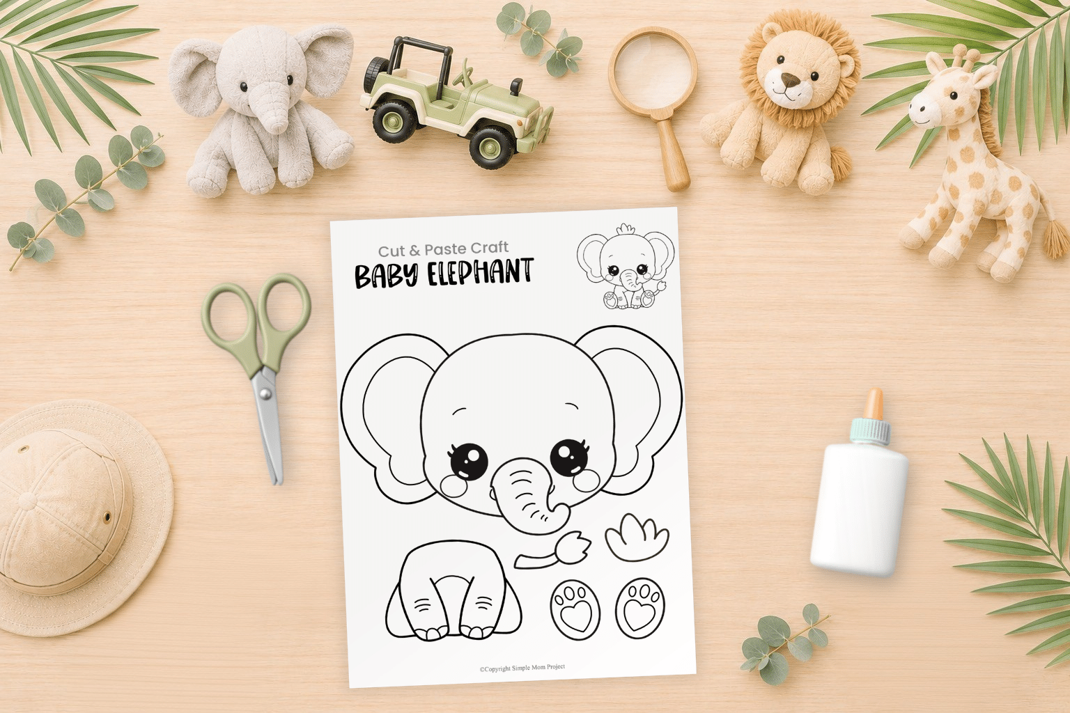 Baby elephant cut and paste craft printable featured in a safari-themed preschool flatlay with craft supplies and coloring materials.